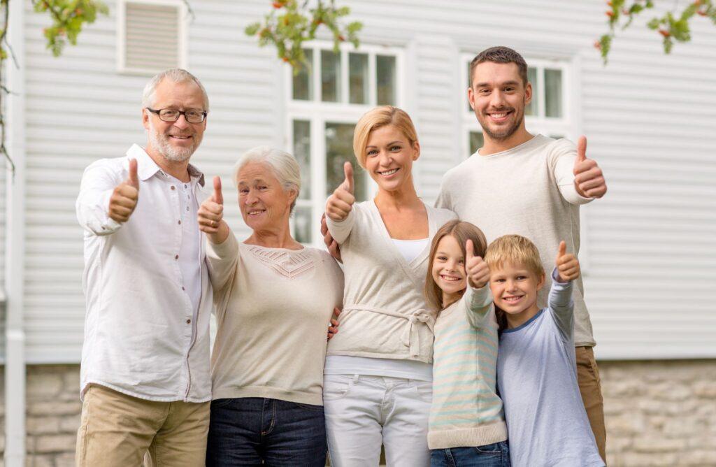 Fröhliche Familie vor dem Haus im Freien