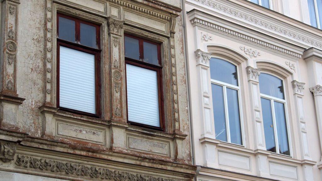 haussanierung an altbaufassade mit direktem vergleich von ungepflegtem und modernisiertem gebaeudeteil
