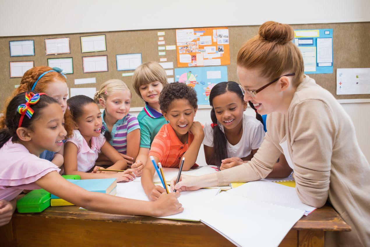 Kinder aus verschiedenen Kulturen arbeiten gemeinsam in einer bilingualen grundschule berlin an einem Projekt