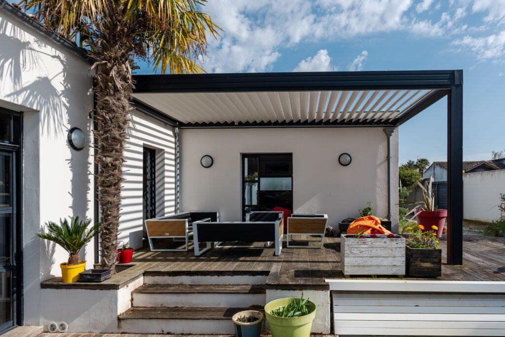 Terrassenüberdachung aus Aluminium mit Lamellendach an modernem Einfamilienhaus